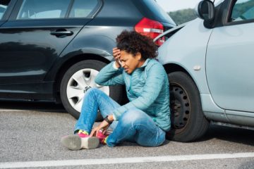 a woman holding her head after a head on car wreck