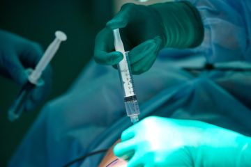 Close up picture of doctor 's hand while inject the anesthetic agent under the patient 's skin.