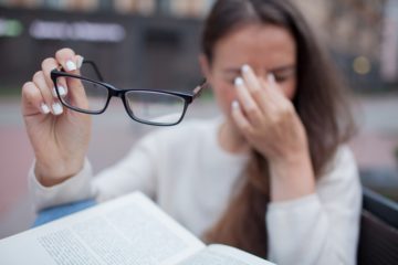 Woman taking her eyeglasses losing her vision.