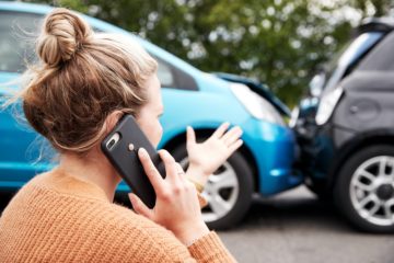 Woman driver reporting car accident to police.