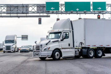 White truck trailer passing the highway.