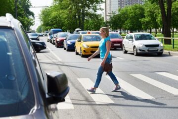 Woman pedestrian crossing street.